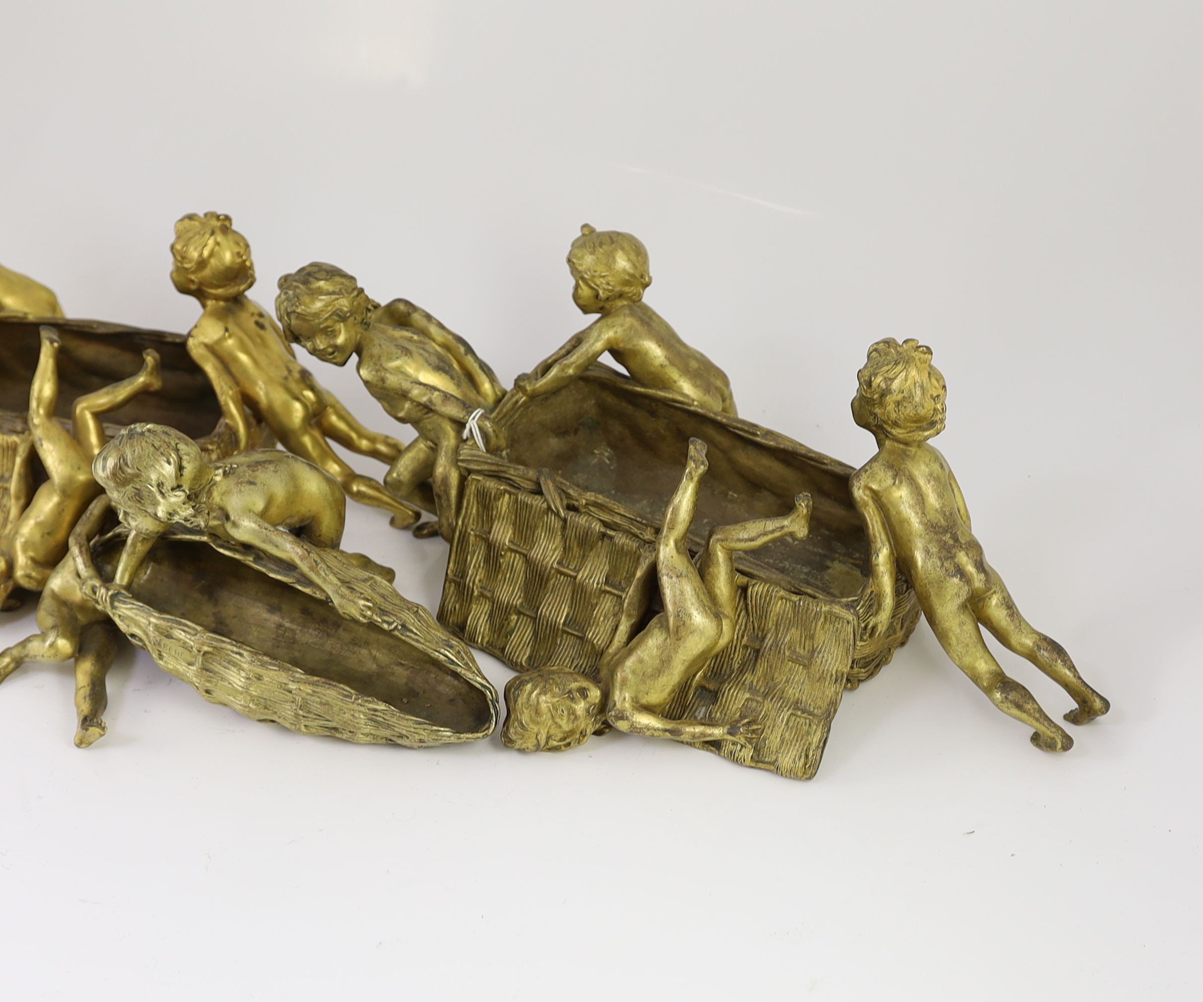 Raoul Francois Larche (French, 1860 - 1912). A set of three ormolu groups of children pushing and pulling large wicker baskets, largest length 45cm height 17cn smaller length 27cm height 16cm